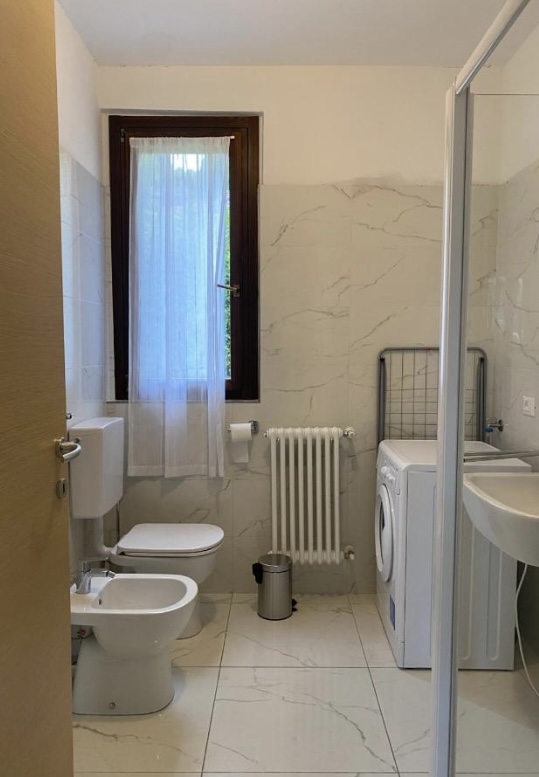 Badkamer van het appartement in Argegno met wasmachine