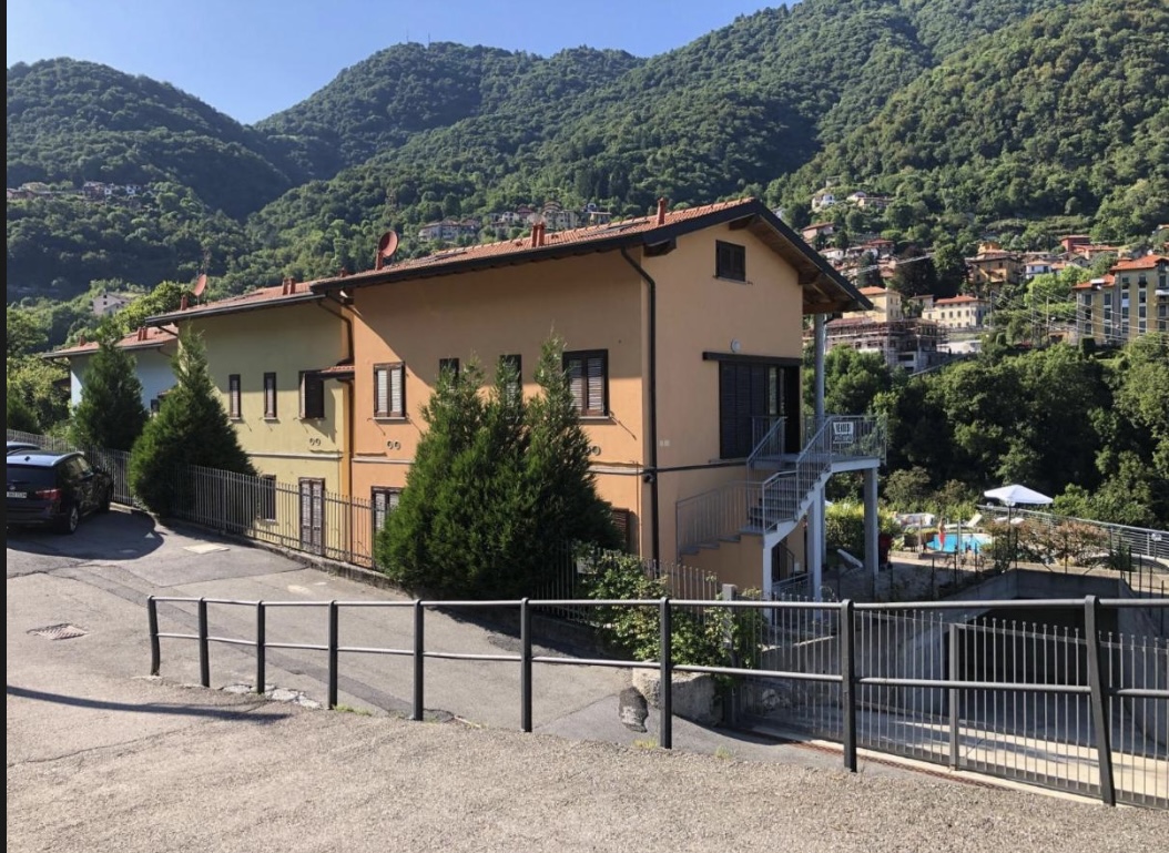 Het appartementengebouw in Argegno met de bergen erachter