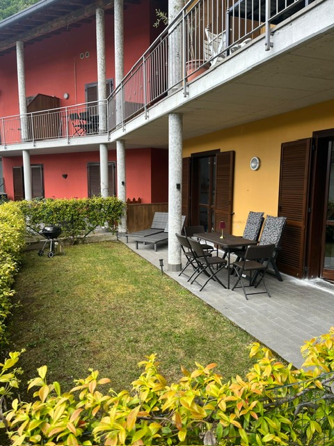 Terras met tuinset en ligbedden bij het appartement in Argegno